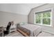 Cozy bedroom with gray comforter, desk, and window bringing in ample natural light at 59 Mill Rd, Pittsboro, NC 27312