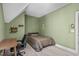 Bedroom with a single bed, desk, chair, and decorative shelving with unique angular ceiling at 59 Mill Rd, Pittsboro, NC 27312