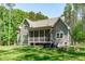Rear exterior of home with a large screened porch, stone patio and fire pit at 59 Mill Rd, Pittsboro, NC 27312