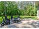 Backyard stone fire pit with chairs on a large patio surrounded by a lush lawn at 59 Mill Rd, Pittsboro, NC 27312