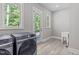 Bright laundry room with sink, wood-look floors, backyard access, and a window for natural light at 59 Mill Rd, Pittsboro, NC 27312