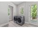 Modern laundry room features gray washer and dryer set, light gray walls, and a door to the outside at 59 Mill Rd, Pittsboro, NC 27312