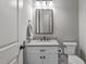 Charming powder room with white vanity, marble countertop, bronze fixtures, and a toilet at 59 Mill Rd, Pittsboro, NC 27312