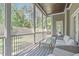 Relaxing screened porch with wicker seating, ceiling fan, wood ceiling and serene backyard views at 59 Mill Rd, Pittsboro, NC 27312