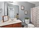 Cozy bathroom with vanity, framed prints, decorative shower curtain, and grey painted walls at 59 Nevada Ct, Clayton, NC 27527