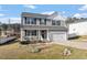 Beautiful two-story home boasts a cozy front porch with comfortable seating, perfect for enjoying quiet mornings at 59 Nevada Ct, Clayton, NC 27527