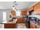 Well-lit kitchen featuring wood cabinets, black appliances, and an island at 59 Nevada Ct, Clayton, NC 27527