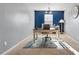 Well-lit home office featuring a large desk, comfortable chair, and a calming blue accent wall at 59 Nevada Ct, Clayton, NC 27527