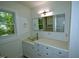 Bathroom vanity featuring a glass bowl sink, tiled counter and a large mirror at 6017 Whitaker Ln, Raleigh, NC 27603