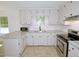 Kitchen with stainless steel appliances, light countertops and cabinets and modern fixtures, with a large window at 6017 Whitaker Ln, Raleigh, NC 27603