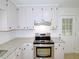 Kitchen with stainless steel appliances, light countertops and cabinets and modern fixtures and adjacent back door at 6017 Whitaker Ln, Raleigh, NC 27603