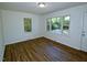 Inviting living room featuring ample natural light, beautiful hardwood floors, and a fresh, neutral color palette at 6017 Whitaker Ln, Raleigh, NC 27603