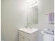 Bright bathroom featuring a white vanity sink, a mirror, and toilet with neatly folded towels at 603 Middleton Ave, Cary, NC 27513
