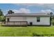 The home's backyard with a small wooden deck, manicured lawn and white vinyl siding at 605 Larchwood Dr, Durham, NC 27713