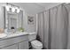 Bright bathroom featuring granite counters, modern fixtures, and gray shower curtain at 605 Larchwood Dr, Durham, NC 27713