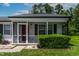 Inviting screened-in front porch with a bright red door and neat landscaping adding charm to the entrance at 605 Larchwood Dr, Durham, NC 27713