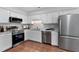 Modern kitchen featuring stainless steel appliances, bright cabinets, and practical layout for cooking at 605 Larchwood Dr, Durham, NC 27713