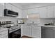 Clean kitchen with stainless steel appliances, white cabinets, and lovely countertops and backsplash at 605 Larchwood Dr, Durham, NC 27713