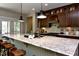 Open kitchen featuring a large granite island, stainless steel appliances, stylish pendant lights, and wood floors at , Wake Forest, NC 27587