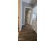 Hallway with hardwood flooring leading to a carpeted room with neutral paint at 626 Hoover Rd, Durham, NC 27703
