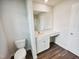 Bathroom featuring a toilet and vanity with white cabinets and a modern sink at 631 Southwick Pl, Mebane, NC 27302