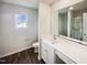 Well-lit bathroom features a large mirror, expansive vanity, and stylish wood-look flooring at 631 Southwick Pl, Mebane, NC 27302