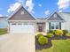 Charming single-story home with stone accents, a two-car garage, and a well-manicured lawn at 631 Southwick Pl, Mebane, NC 27302