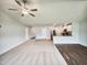Bright open-concept living area featuring a ceiling fan, open kitchen, and neutral tones at 631 Southwick Pl, Mebane, NC 27302