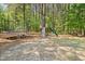 A backyard featuring a trampoline, treehouse, and slide in a wooded area, perfect for outdoor fun and recreation at 7227 Cleveland Rd Rd, Clayton, NC 27520