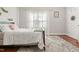 Bedroom with a wood-framed bed, patterned rug, and bright natural light coming from the window at 7227 Cleveland Rd Rd, Clayton, NC 27520