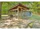 This is a large outdoor wooden dog kennel with wire walls, and roof, surrounded by lush greenery on a sunny day at 7227 Cleveland Rd Rd, Clayton, NC 27520