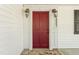 Inviting red front door with classic sconces and stone landing at 7227 Cleveland Rd Rd, Clayton, NC 27520
