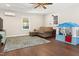 Spacious living room featuring wood floors, a ceiling fan, and plenty of natural light at 7227 Cleveland Rd Rd, Clayton, NC 27520
