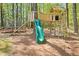 Backyard playground with a slide, swing, and climbing wall, surrounded by mature trees, great for ' entertainment at 7227 Cleveland Rd Rd, Clayton, NC 27520