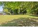 A sprawling backyard with lush green grass and mature trees offers ample space for recreation and relaxation at 7227 Cleveland Rd Rd, Clayton, NC 27520