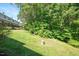 Lush green backyard of townhome, surrounded by mature trees and well-maintained lawn at 7616 Satinwing Ln, Raleigh, NC 27617