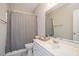 Stylish bathroom featuring a striped shower curtain, a vanity with ample counter space, and a well-maintained appearance at 7616 Satinwing Ln, Raleigh, NC 27617
