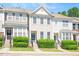 View of townhome exteriors showing lawn, entrance and multiple windows at 7616 Satinwing Ln, Raleigh, NC 27617
