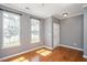 Bright living room featuring gleaming hardwood floors and large windows at 7616 Satinwing Ln, Raleigh, NC 27617