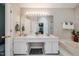 Bathroom featuring double sink vanity with a large mirror, bathtub, and glass shower at 8 Wexford Dr, Durham, NC 27713