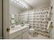 Bright bathroom with white vanity, toilet, and a shower with a charming, colorful shower curtain at 8 Wexford Dr, Durham, NC 27713