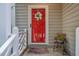 Inviting front porch with a decorative wreath on a red door and colorful flowers at 8 Wexford Dr, Durham, NC 27713
