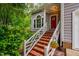 Charming front entrance with brick steps, white railing, and vibrant green foliage at 8 Wexford Dr, Durham, NC 27713