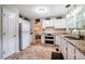 Efficient kitchen featuring ample counter space, white cabinets, and stainless steel appliances at 8 Wexford Dr, Durham, NC 27713