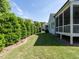 Grassy backyard showing the rear of the house and screen porch at 8461 Lentic Ct, Raleigh, NC 27615