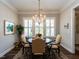 Elegant dining room with hardwood floors, chandelier, and large windows with shutters at 8461 Lentic Ct, Raleigh, NC 27615