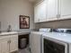 Functional laundry room with granite countertops, a sink and modern washer/dryer at 8461 Lentic Ct, Raleigh, NC 27615