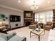 Spacious living room with a stone fireplace, elegant chandelier, and comfortable seating at 8461 Lentic Ct, Raleigh, NC 27615