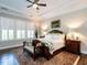 Cozy main bedroom featuring plantation shutters, tray ceilings, and hardwood flooring at 8461 Lentic Ct, Raleigh, NC 27615