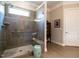 Walk-in shower with tile and glass door next to a light turquoise ceramic stool at 8461 Lentic Ct, Raleigh, NC 27615